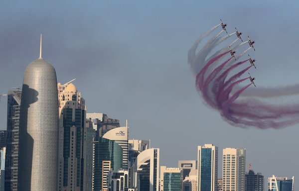 Aircraft perform during a military parade to mark Qatar's national day celebration, on December 18th in Doha. [Karim Jaafar/AFP] 