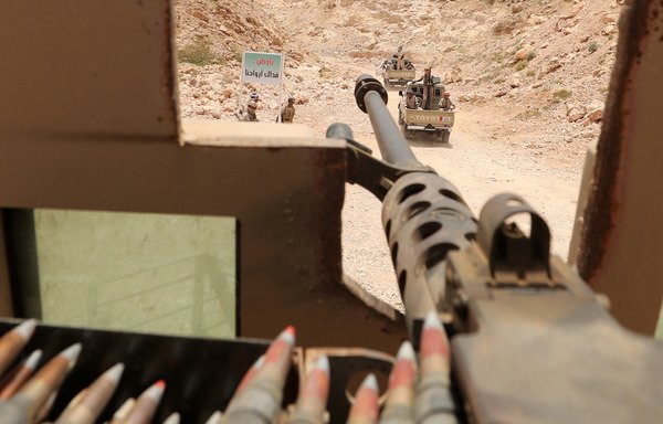 A picture taken from a UAE military vehicle on August 8th, 2018 shows Yemeni soldiers riding armed pickups through a mountain road north of the Hadramaut provincial capital of al-Mukalla. [Karim Sahib/AFP]