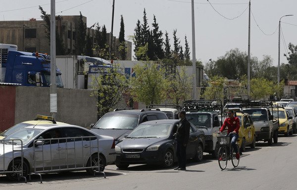 Syrians queue to fill their cars at a gas station in Damascus on April 8th. The lines at the stations were the latest sign of a fuel crisis hitting regime-held parts of Syria. [Louai Beshara/AFP]