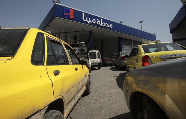Taxis and other civilian vehicles queue at a gas station in Damascus on April 8th. The regime has been facing a flurry of international sanctions since the conflict started in 2011, including over the import of petroleum-related products. [Louai Beshara/AFP]