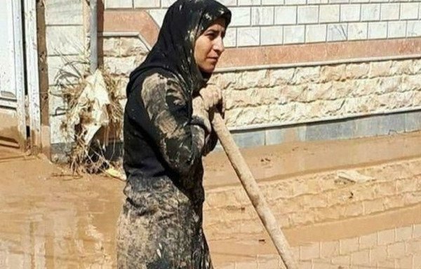 An Iranian woman wades through floodwater to help remove debris amid a lack of government support after the floods that have hit many provinces in Iran since March 19th. [Photo circulated on social media]