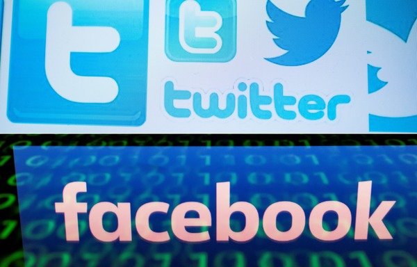 This combination of pictures created on August 22nd, 2018 shows a photo illustration taken March 23rd, 2018 of Twitter logos on a computer screen in Beijing and a file illustration picture taken April 28th, 2018 of the Facebook logo displayed on a screen and reflected on a tablet in Paris. [Nicolas Asfouri/Lionel Bonaventure/AFP]