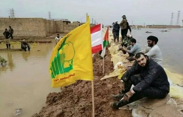 Members of Lebanon's Hizbullah post their flag in Iran's flood-stricken Ahwaz region. [Photo circulated on social media]