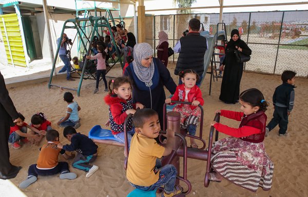 أطفال لاجئون يلعبون على أرجوحة في مخيم الزعتري في الأردن في 9 نيسان/أبريل. [خليل مزرعاوي/وكالة الصحافة الفرنسية]