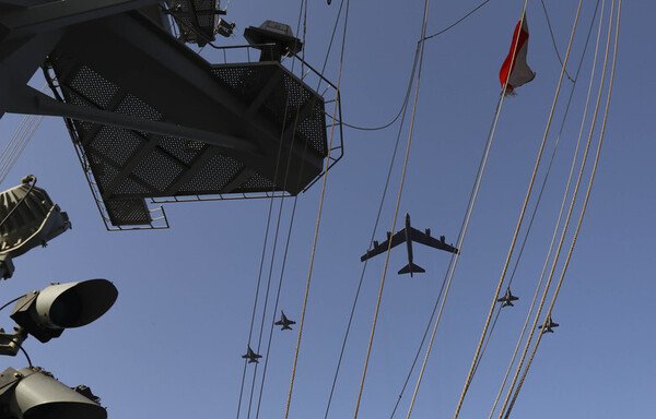 A US Air Force B-52H Stratofortress bomber flies with an escort squadron above the aircraft carrier USS Abraham Lincoln during training exercises in Gulf waters aimed at ensuring full readiness on June 1st. [US Navy]
