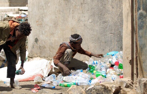 Yemeni boys collect plastic materials from a garbage dump to sell for recycling, in the capital Sanaa on March 16th, 2019. The Iran-backed Houthis are manipulating currency prices in areas under their control, compounding the humanitarian suffering of Yemenis. [Mohammed Huwais/AFP]