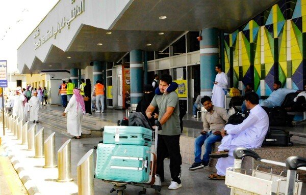 Travelers gather in front of the arrivals lounge at the Abha airport in southern Saudi Arabia on July 2nd. A Yemeni Houthi attack on the civilian airport wounded nine civilians that day. [AFP]