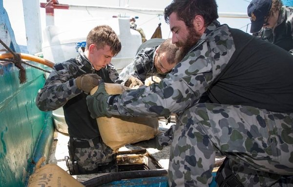 Members of the Royal Australian Navy frigate HMAS Ballarat remove bags containing suspected narcotics during a search of a suspicious dhow in the Arabian Sea in early June 2019. [Photo courtesy of the Australian Defence Force]
