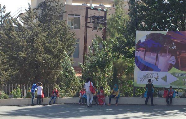 مجموعة من الأطفال السوريين على جانب الطريق في خربة قنافار غرب البقاع، ينتظرون من يُقلّهم إلى المخيم حيث يقطنون في برالياس بعد يوم طويل من جني الفواكه. [نهاد طوباليان/المشارق]