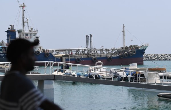 A man watches ships on July 2nd in the port of Fujairah in the east of the UAE, where recent tensions between Iran and the US have affected movement in the Gulf of Oman, near the Strait of Hormuz. [Karim Sahib/AFP]