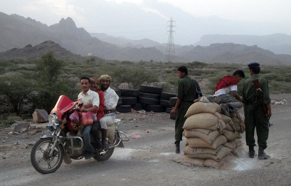 Three men on a motorcycle drive past an army checkpoint at the entrance to Yemen's Abyan province in this file photo from August 31st, 2010. [AFP PHOTO/STR]