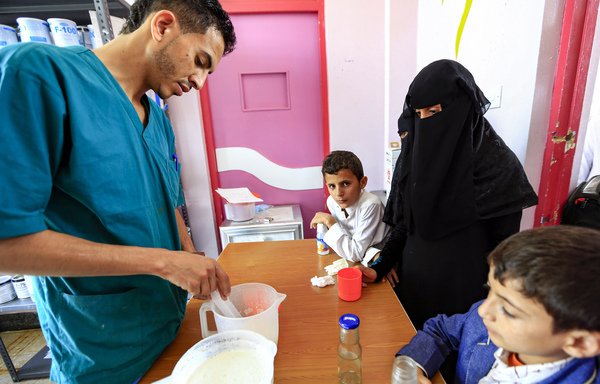 ممرض يحضر في 22 حزيران/يونيو الحليب لأطفال يعانون من سوء التغذية في مركز علاج بمستشفى السبعين للأمومة في مدينة صنعاء الخاضع للحوثيين. [محمد حويس/وكالة الصحافة الفرنسية]