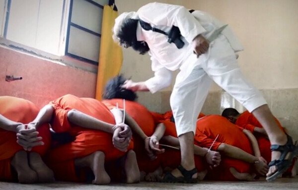 A screen shot of a 2016 video released by ISIS on Eid al-Adha, moments before one of its fighters slits the throats of the group's Syrian victims. [File]