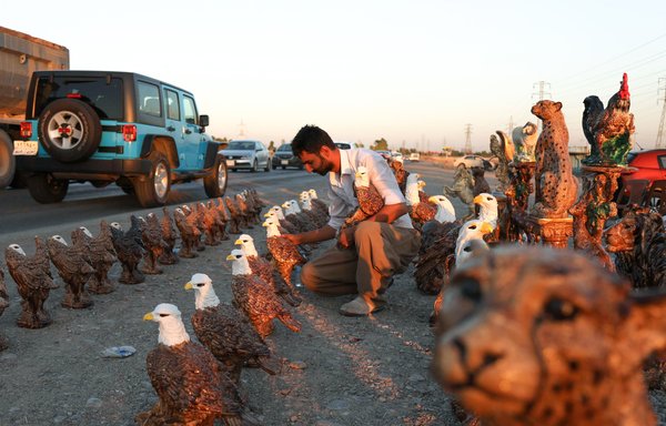 Suleiman Taha, a 28-year-old maths graduate from Iran's western Sanandaj, sells handmade gypsum animal sculptures in Erbil, the capital of Iraq's Kurdish region, on July 2nd. [Safin Hamed/AFP]