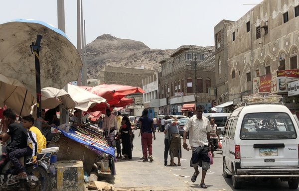 Yemenis walk in a street market in Aden on August 11th, following clashes between pro-government forces and separatists. [Nabil Hasan/AFP]