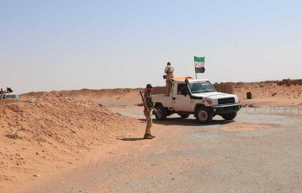 عناصر من جيش مغاوير الثورة يقومون بتأمين وفد من الأمم المتحدة والهلال الأحمر السوري خلال زيارته لمخيم الركبان على الحدود الجنوبية لسوريا مع الأردن في منتصف آب/أغسطس. [حقوق الصورة لطارق النعيمي]