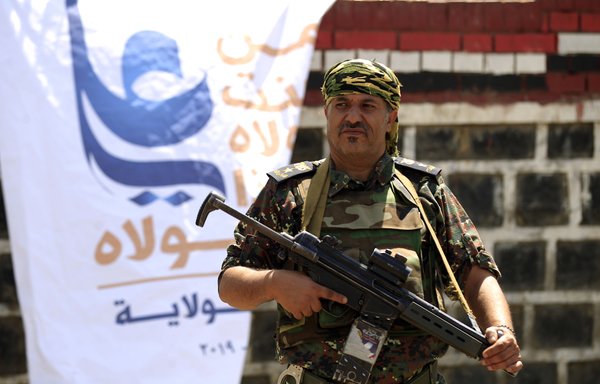 A member of the security forces loyal to the Houthis stands guard August 19th during a gathering in Sanaa. [Mohammed Huwais/AFP]