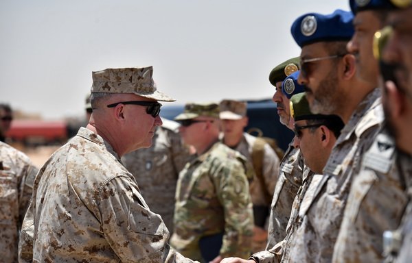 US Marine Corps Gen. Kenneth F. McKenzie Jr., commander of the US Central Command, shakes hands with Saudi military officers during his visit to a military base in al-Kharj in central Saudi Arabia on July 18th.  [Fayez Nureldine/AFP]