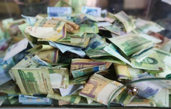 صورة التقطت في 23 نيسان/أبريل تظهر أوراقا نقدية إيرانية في صندوق تبرعات وسط طهران. [عطا كيناري/وكالة الصحافة الفرنسية]