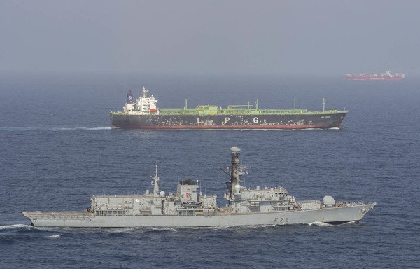 HMS Kent accompanies a British-flagged ship through the Strait of Hormuz. [Royal Navy]