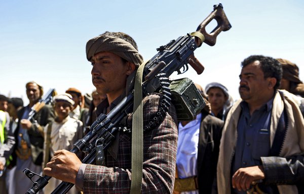 A Yemeni man carries a machine-gun on his shoulder during a tribal meeting in Houthi-held Sanaa on September 21st. [Mohammed Huwais/AFP]