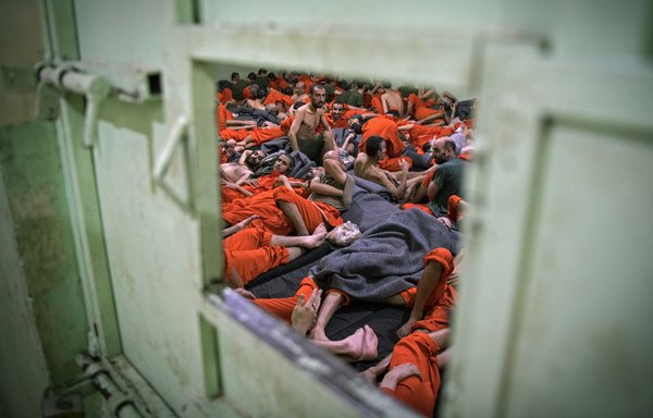 Suspected members of ISIS gather in a prison cell in al-Hasakeh on October 26th. Kurdish sources say around 12,000 ISIS fighters, including Syrians, Iraqis as well as foreigners from 54 countries are being held in Kurdish-run prisons in northern Syria. [Fadel Senna/AFP]