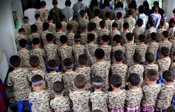 مقاتلون أويغور من الحزب الإسلامي التركستاني وأطفالهم يؤدون الصلاة في أحد المخيمات بسوريا. [الصورة متداولة على نطاق واسع على شبكة الإنترنت من خلال الحزب الإسلامي التركستاني في سوريا]