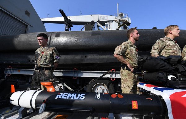 British divers aboard Britain's RFA Cardigan Bay landing ship in the Gulf waters off Bahrain stand next to equipment during the International Maritime Exercise (IMX), on November 5th. [Karim Sahib/AFP]