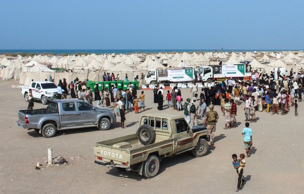 Displaced Yemenis gather to receive Saudi-provided food aid at a camp for the displaced in the Khokha district of al-Hodeidah on January 21st. [Saleh al-Obeidi/AFP]
