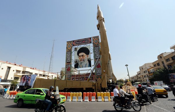 A Shahab-3 surface-to-surface missile is displayed next to a portrait of Iranian Supreme Leader Ali Khamenei at the Baharestan Square in Tehran on September 26th. [STR/AFP]