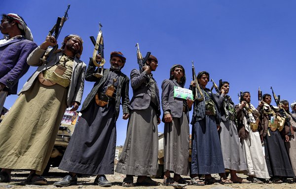 Yemeni men chant slogans as they hold up Kalashnikov assault rifles during a tribal meeting in Sanaa on September 21st, as tribesmen donate rations and funds to fighters loyal to the Houthis along the fronts. [Mohammed Huwais/AFP]