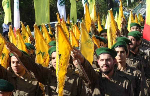Fighters from Lebanon's Hizbullah take part in a military parade marking Martyrs' Day in the southern town of Ghazieh, south of the port city of Sidon, on November 12th. [Mahmoud Zayyat/AFP]