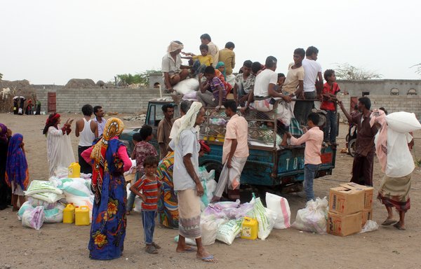 Displaced Yemenis from Durahemi receive food aid in the Red Sea port city of al-Hodeidah on August 9th. [AFP]