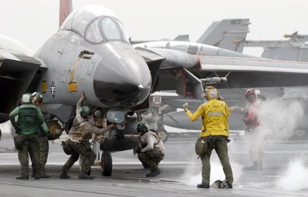 This handout photo provided by the US Navy in March 2003 shows a flight deck director directing an F-14D Tomcat onto one of four steam powered catapults as 'final checkers' conduct their inspections before the fighter is launched from the flight deck of USS Abraham Lincoln (CVN 72) in the Arabian Gulf. [AFP PHOTO/HO/US NAVY/Philip A. McDaniel]