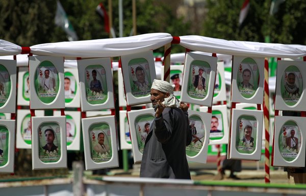 A Yemeni man walks past portraits of Houthis reportedly killed in battle on February 27th, 2016 in Sanaa. [Mohammed Huwais/AFP] 