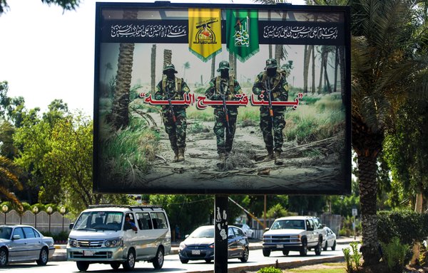 A picture taken in central Baghdad on June 20th, 2018, shows a propaganda billboard for the Iran-aligned Kataib Hizbullah militia. [Ahmad al-Rubaye/AFP]