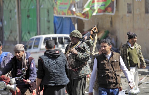 A Houthi fighter slings a heavy machine gun on his shoulder as he walks down a street where the militia had clashed with loyalists of Yemen's slain ex-president Ali Abdullah Saleh, in Sanaa on December 6th, 2017. [Mohammed Huwais/AFP]