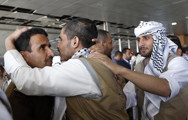 A Houthi prisoner embraces a man on November 28th upon his arrival at the airport in Sanaa, following his release, along with other prisoners, by the Saudi-led coalition. [Mohammed Huwais/AFP]