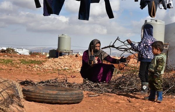لاجئ سوري يقطع الحطب لاستخدامه لطهي الطعام في مخيم للاجئين في لبنان. [حقوق الصورة لمفوضية الأمم المتحدة العليا لشؤون اللاجئين]