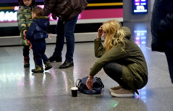 A woman reacts at the arrival gate of the Boryspil airport outside Kiev on January 8th after a Ukrainian airliner carrying 176 people crashed shortly after takeoff from Tehran, killing all on board. [Sergei Supinsky/AFP]