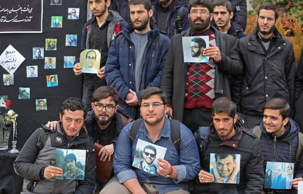 Iranian students hold pictures of victims during a memorial for the passengers of the Ukraine plane at the University of Tehran on January 14th. [Atta Kenare/AFP]