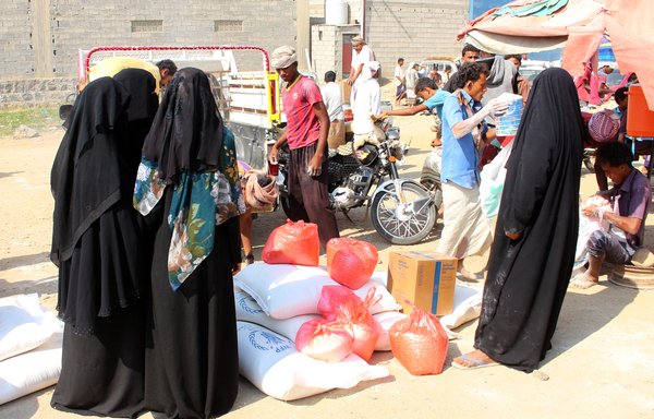 Displaced Yemenis receive humanitarian aid, donated by the World Food Programme (WFP) in co-operation with the Danish Refugee Council, in Hajjah province on December 30th, 2019. [Essa Ahmed/AFP]
