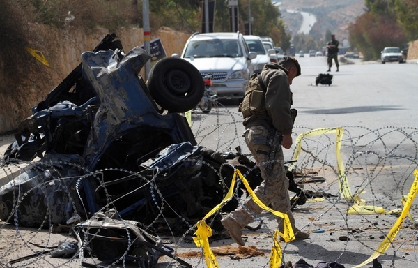 A member of the Lebanese forces works near a burnt out vehicle at the site of a car bomb that targeted a checkpoint in Hermel, killing at least two soldiers and a civilian, in this file photo from February 23rd, 2014. The attack was claimed by al-Nusra Front. [AFP PHOTO/STR]