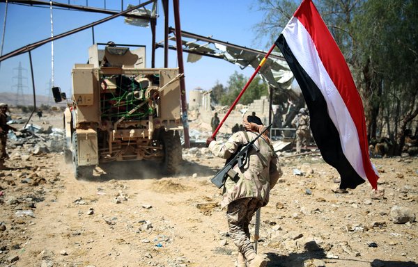 A Yemeni tribesman from the pro-government Popular Resistance Committees holds a Yemeni flag in the Nehm camp west of Marib city, in this file photo from February 11th, 2016. [Abdullah al-Qadry/AFP]