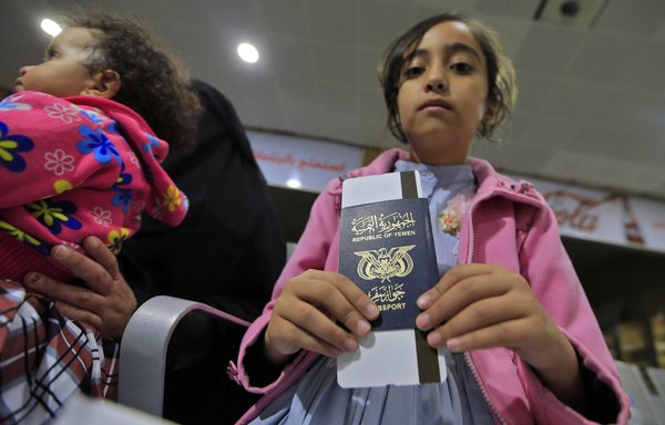 A child patient holds a passport while waiting at Sanaa International Airport on February 3rd for evacuation aboard a UN aircraft bound for Amman to receive medical treatment. [Mohammed Huwais/AFP]