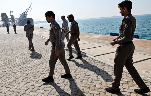 Saudi security forces walk along a pier at the docks of Ras al-Khair port, about 185 kilometres north of Dammam in Saudi Arabia's Eastern Province overlooking the Gulf, on December 11th, 2019. [Giuseppe Cacace/AFP]