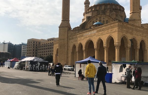 Lebanese people walk near protestors' tents in Beirut's Martyrs' Square on February 17th. [Nohad Topalian/Al-Mashareq] 