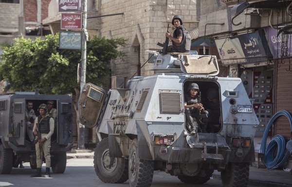 A picture taken on July 26th, 2018 shows Egyptian policemen standing guard on a street in the North Sinai provincial capital of al-Arish. [Khaled Desouki/AFP]