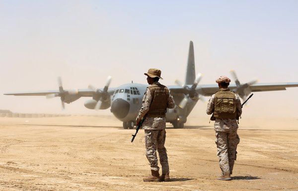 Saudi soldiers stand guard before aid supplies are unloaded from a Saudi air force cargo plane at an airfield in Yemen's Marib province on March 12th, 2018. The Saudi-led Arab coalition is backing a Yemeni push to recapture parts of the province from the Houthis. [Abdullah al-Qadry/AFP]