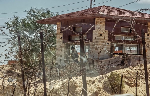 A picture taken on July 26th, 2018 shows Egyptian policemen standing guard at a checkpoint on a road leading to the North Sinai provincial capital of al-Arish. [Khaled Desouki/AFP]